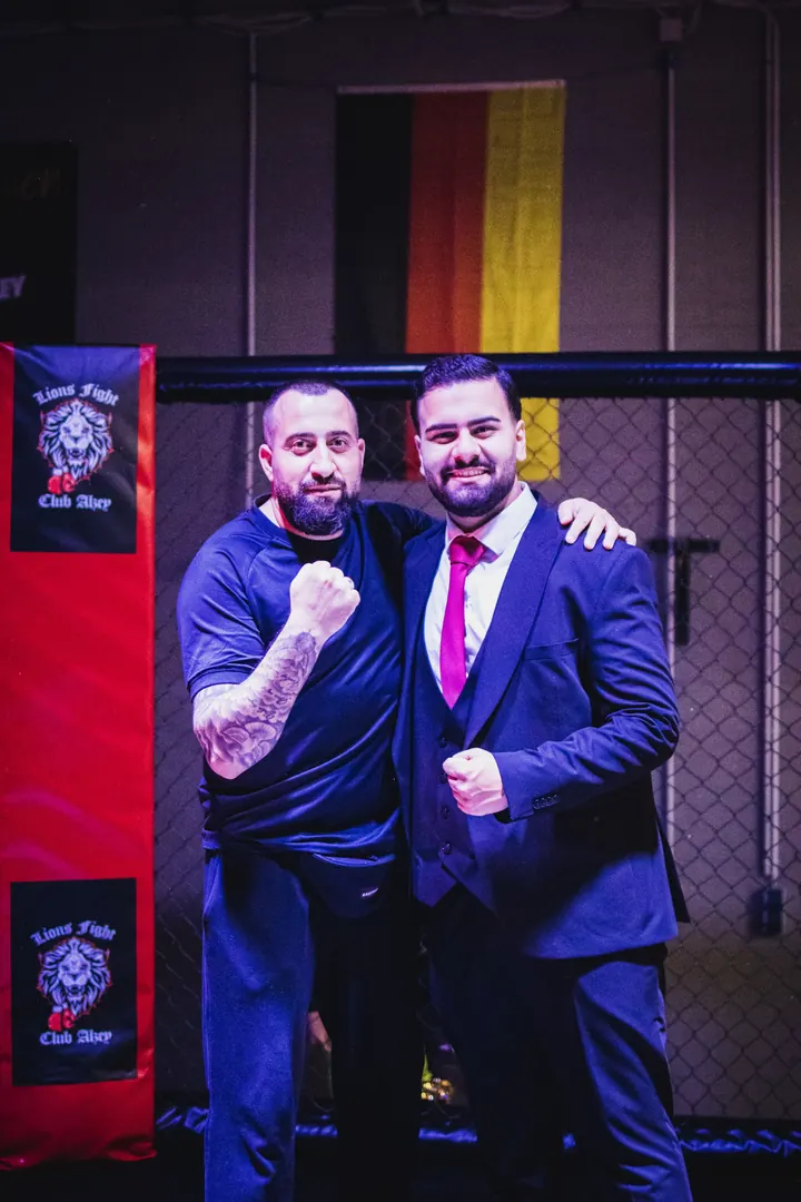Umut Yagmur und ein Gast mit erhobener Faust im Käfig